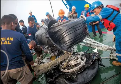  ?? AP/FAUZY CHANIAGO ?? Rescuers in 2018 inspect wreckage from the crash of a Lion Air Boeing 737 Max airliner in Indonesia that killed 189 people.