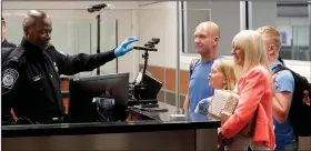  ?? AP/JOHN RAOUX ?? A U.S. Customs agent screens a family with face recognitio­n software Thursday at Orlando Internatio­nal Airport.