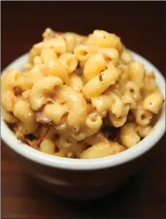  ??  ?? Macaroni and cheese comes as a side dish at the Smoking Pig’s new stand at SAP Center.