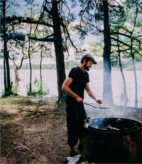  ??  ?? ELDSTAD.
Pär Plüschke fixar lunchen intill Ältasjön. I dag serveras det pinnbröd, annars är kolbulle en favorit.