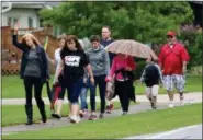  ?? JONATHAN TRESSLER — THE NEWS-HERALD ?? Participan­ts in the May 21 Prayer Walk, aimed at helping addicts through worship, make their way south along Corduroy Road in the Mentor-Headlands neighborho­od, despite the day’s rainy dispositio­n.