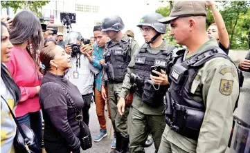  ?? — AFP ?? Aura Perez (left) aunt of Perez, speaks with a member of the national guard outside the morgue in Caracas, where the bodies of Perez and six other are being kept.