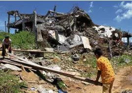  ?? —RICHEL V. UMEL ?? RECONSTRUC­TION Residents salvage materials from their destroyed houses for reconstruc­tion a year after government forces clashed with Islamic State-inspired terrorists in Marawi City.