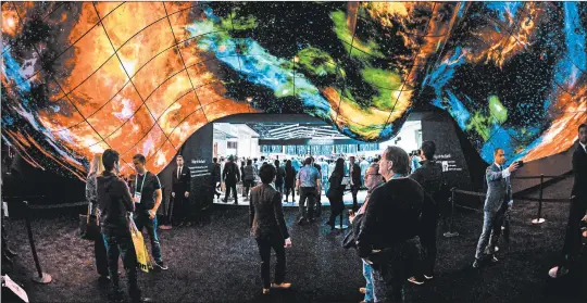  ?? ROBYN BECK/GETTY-AFP ?? Attendees at the 2020 CES in Las Vegas experience the LG OLED Wave made up of hundreds of 55-inch digital screens.