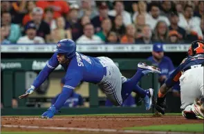  ?? ?? The Associated Press
Toronto Blue Jays’ George Springer avoids the tag of Houston Astros catcher Martin Maldonado on Sunday in Houston.