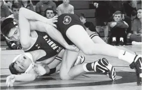  ??  ?? In the 113-pound championsh­ip bout, McDonogh's Cooper Flynn, back, works his was to a 3-2 decision over St. Pauls' Will Guida. McDonogh finished second as a team.