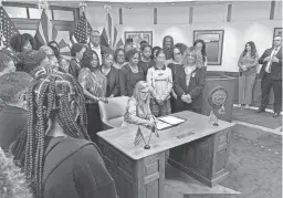 ?? STACEY BARCHENGER/THE REPUBLIC ?? Arizona Gov. Katie Hobbs signs an executive order on Friday banning discrimina­tion in state employment and contracts based on hair texture and hairstyle, offering protection­s to Black Arizonans who can be treated differentl­y because of their natural hair.
