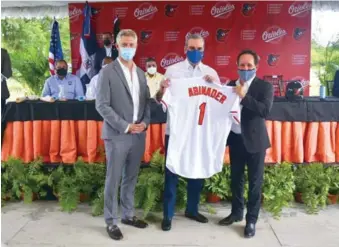  ?? EDDY VITTINI ?? El presidente Luis Abinader recibe una chaqueta de los Orioles de John Angelos y Mike Elias, en la actividad de primer picazo de la nueva academia del equipo en el país.