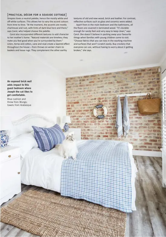  ??  ?? An exposed brick wall adds impact to this guest bedroom where Joseph the cat likes to get comfortabl­e. Blue cushion and throw from Mungo; towels from Arabesque