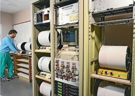  ??  ?? The volcano monitoring room at the GNS Science Wairakei office in 1993, with volcanolog­ist Brad Scott checking paper records for signs of unusual seismic activity under Mt Ruapehu.