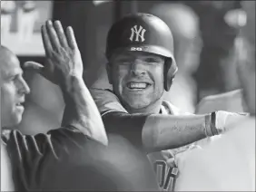  ?? RON SCHWANE/AP PHOTO ?? The Yankees’ Austin Romine celebrates in the dugout after scoring the go-ahead run on a double and two Indians’ errors on the play during the seventh inning of Saturday’s game in Cleveland. The Yankees won, 5-4.