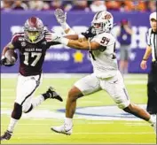  ?? Michael Wyke Associated Press ?? TEXAS A&M’S Ainias Smith (17) fends off Oklahoma State’s Trace Ford during Friday’s Texas Bowl.