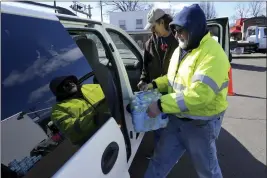 ?? MATT FREED — THE ASSOCIATED PRESS ?? Volunteer Larry Culler helps load water into a car in East Palestine, Ohio, as cleanup from the Feb. 3Norfolk Southern train derailment continues, Friday.