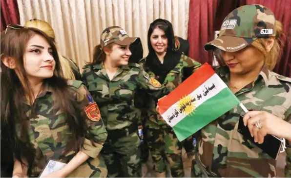  ?? —AFP ?? ARBIL: Female members of a Kurdish Peshmerga battalion queue inside a polling station as they wait to cast their vote in the Kurdish independen­ce referendum in Arbil yesterday.