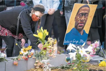  ?? JOHN MINCHILLO/AP ?? A demonstrat­or places flowers at a memorial outside Cup Foods in Minneapoli­s on April 20 as supporters gathered to celebrate the murder conviction of former Minneapoli­s police officer Derek Chauvin in the killing of George Floyd.