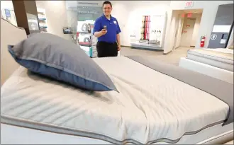  ??  ?? John Yelverton demonstrat­es the sleep technology that not only tracks your sleeping patterns, but works in concert with a number of features of the Sleep Number 360 Smart Bed, including a foot-warming element, adjustable side comfort, head and foot...