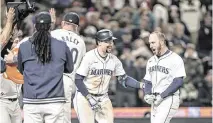  ?? STEPHEN BRASHEAR USA TODAY Sports ?? Mariners designated hitter Mitch Garver, right, celebrates with teammates including second baseman Cal Raleigh, second from right, after hitting a two-run home run during the ninth inning against the Atlanta Braves on Monday in Seattle.