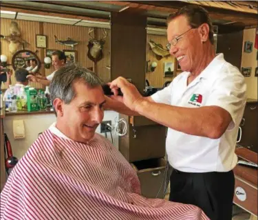  ?? DAVID S. GLASIER — THE NEWS-HERALD ?? Frank Mansi, right, cuts the hair of longtime customer Mike Beres at Mansi’s Barber Shop in Euclid.