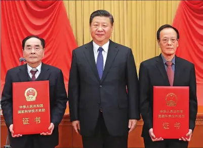  ?? JU PENG / XINHUA ?? President Xi Jinping stands between Hou Yunde (left) and Wang Zeshan, who won China’s top science award on Monday for their outstandin­g contributi­ons to scientific and technologi­cal innovation, at the Great Hall of the People in Beijing.