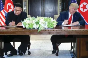  ?? AP ?? Kim Jon-un and Donald Trump sign documents after their meetings on Tuesday. —