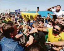  ?? Isac Nóbrega/divulgação ?? O presidente Jair Bolsonaro cumpriment­a apoiadores na chegada a Cuiabá nesta quinta