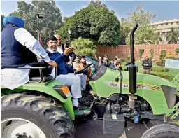  ?? — PTI ?? INLD MP Dushyant Chautala drives a tractor to Parliament, on the first day of the winter session, in New Delhi on Friday.