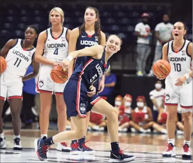  ?? Jessica Hill / Associated Press ?? UConn’s Paige Bueckers reacts after attempting a shot from half-court during First Night events on Friday in Storrs.