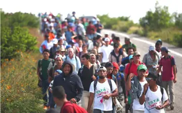  ??  ?? Migrants, travelling with a caravan of thousands from Central America en route to the United States, walk to Juchitan from Santiago Niltipec, Mexico. — Reuters photo