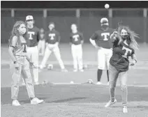  ?? MICHAEL LAUGHLIN/SUN SENTINEL ?? Hailey Stein throws out the first pitch to honor her late father and former Taravella baseball coach Jason Stein before the start of a game against South Broward on Wednesday.