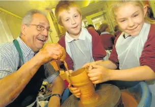  ??  ?? ●●Potter Frank Mottram helping Alice Ingham Primary pupils Alex Shaw and Alicia Palombo, both then nine