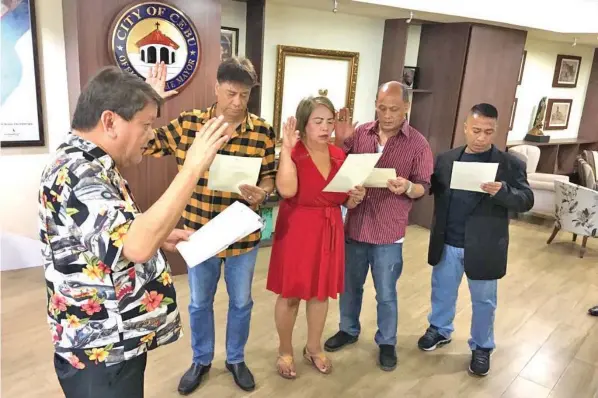  ?? PAUL JUN E. ROSAROSO ?? Newly-elected officials of Barangay Day-as led by Captain Freddie Esmas take their oath before Cebu City Mayor Tomas Osmeña. The officials were former allies of Barug-Team Rama.