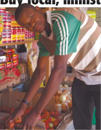  ?? Photo: Nampa ?? Local is lekker… 'KK' Shikongo checks the quality of the fresh produce at his shop in the One Nation informal settlement.