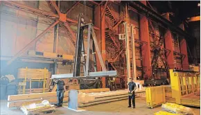  ?? DAVE JOHNSON THE WELLAND TRIBUNE ?? Employees inside Handling Specialty's Hamilton plant move a piece of steel to be used for a machine at GE Welland's Brilliant Factory. The Grimsby company is still building machinery.