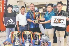  ??  ?? Poh (second right) hands over the sponsorshi­p to George (centre) while Redeems Centre manager Koper Gadung (second left) and LSC staff look on.