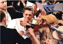  ?? — AFP ?? US actor Brad Pitt (left) takes a picture with a fan during the Japan premiere of his latest movie ‘War Machine’ in Tokyo.