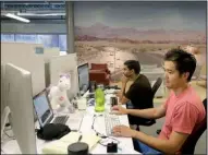  ?? AP/ JEFF CHIU ?? MetroMile employees Allen Tran and Muhammad Waliji work at their desks in a San Francisco office earlier this month. The company sells auto insurance on a per- mile basis.