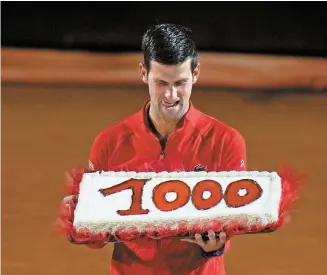  ?? AP-Yonhap ?? Serbia’s Novak Djokovic holds a cake adorned with the number of his 1,000th tour-level wins earned after winning the semifinal match against Norway’s Casper Ruud at the Italian Open tennis tournament, in Rome, Saturday.