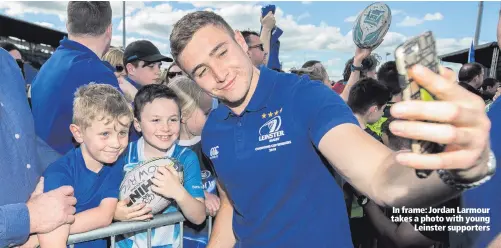  ??  ?? In frame: Jordan Larmour takes a photo with young
Leinster supporters