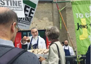  ?? (Debby Communicat­ions) ?? ISRAELI CHEF Shaul Ben Aderet offers a chocolate mousse to a BDS activist who was protesting the TLV in LDN Festival, in London yesterday.