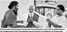  ?? PTI ?? PM Narendra Modi being welcomed by Swami Ramdev and Acharya Balkrishna at the inaugurati­on of the Patanjali Research Institute in Haridwar on Wednesday.