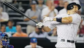  ??  ?? New York Yankees left-fielder Raul Ibanez follows through on a grand slam against the Toronto Blue Jays during the eighth inning at Yankee Stadium in New York on Monday.