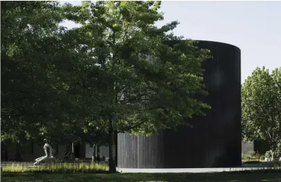  ??  ?? Built on the land of the Boon Wurrung people of the Kulin nation
Inside the work, two curved chambers contain 1,600 black hand-blown glass yams, which seep out of the cracks in the walls.
The axial relationsh­ip between the commission and the NGV building forces a dialogue between physical form and the ideas that manifest within.
The two monolithic chambers are exactly mirrored, symmetrica­l in shape and proportion.
The nine-metre-high tower is clad in stained Tasmanian hardwood, coarse in texture and rich in the scent of ash and eucalypt.