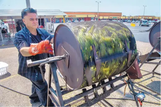  ?? EDDIE MOORE/JOURNAL ?? Johnny Duran, from Taos, is already roasting green chile at his Los Chile Brothers in the parking lot of the Big Lots store on Cerrillos Road.