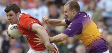  ??  ?? Wexford full-back Philip Wallace trying to get to grips with Armagh attacker Ronan Clarke.