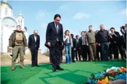  ?? UKRAINIAN FOREIGN MINISTRY PRESS OFFICE VIA AP ?? Japanese Prime Minister Fumio Kishida, center, offers prayers Tuesday at a church in Bucha, a town outside Kyiv that became a symbol of Russian atrocities against civilians, in Ukraine.