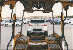  ?? CHASE CASTOR / THE NEW YORK TIMES ?? Dave Pinegar loads his car hauler Tuesday at the Jack Cooper Transport lot in Kansas City, Kan., a way station for many vehicles built at a General Motors plant next door and elsewhere. Before the global supply chain descended into chaos, this terminal ran on a steady and dependable rhythm. Now, no one can plan, and no one is sure what will happen next.