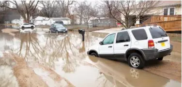  ?? Associated Press ?? ↑ Cars are stuck in floodwater­s in Fremont, Nebrasak, on Tuesday.