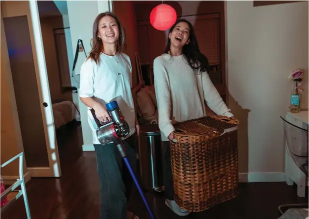  ?? — Photos by Ye Fan/the New York Times ?? Ellicia Chiu and Cher Su in their apartment with their $135 vacuum and $20 double side laundry hamper in the Lower East Side on February 21, 2024.