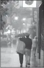  ?? NWA Democrat-Gazette/ANDY SHUPE ?? Pedestrian­s walk Saturday on Dickson Street in Fayettevil­le as heavy rain falls.