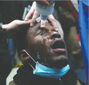  ?? Shanon Stapleton / reuters ?? A Capitol rioter is treated after getting pepper-sprayed during clashes with police on Wednesday in Washington, D.C.